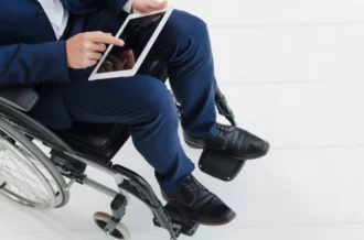 businessman's hand on wheel of wheelchair